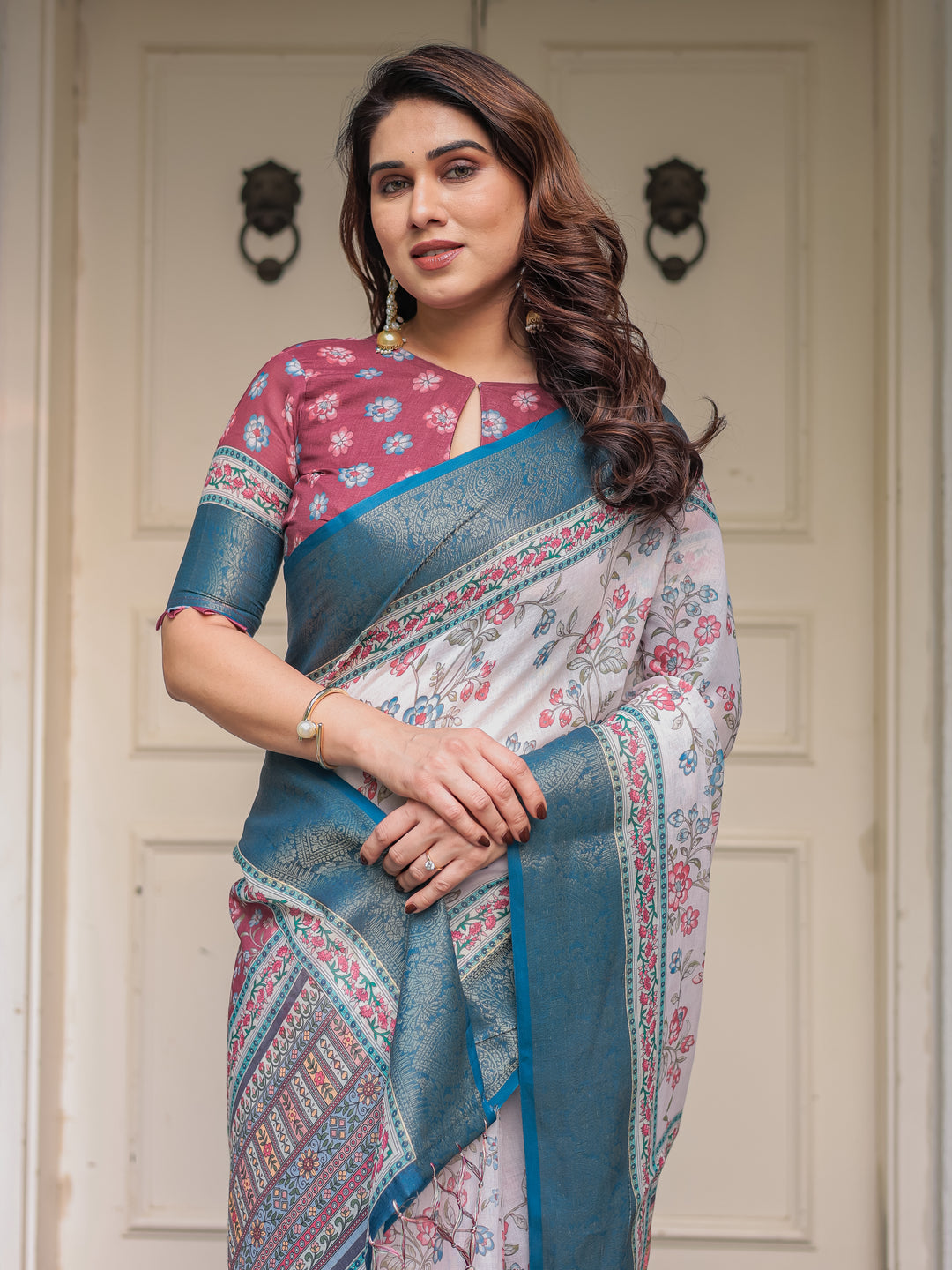 Ivory Floral Printed Saree with Rose Pink & Teal Blue Zari Border & Tassels – Elegant Festive Ethnic Wear